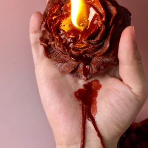 Deep red low-temperature wax play candle with a luxurious gold shimmer, dripping smoothly for a warm sensory experience.